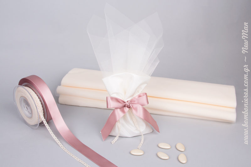 Ρομαντική μπομπονιέρα σε πουγκάκι από ταφτά, διακοσμημένο με σατέν κορδέλα, δαντελένιο φυτίλι και γαλλικό τούλι σε ανοιχτές αποχρώσεις.